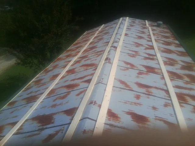 Rusted metal roof panels with new wood purlins before replacement — Storm Damage Roof Repair in Essex by Roofing Brothers