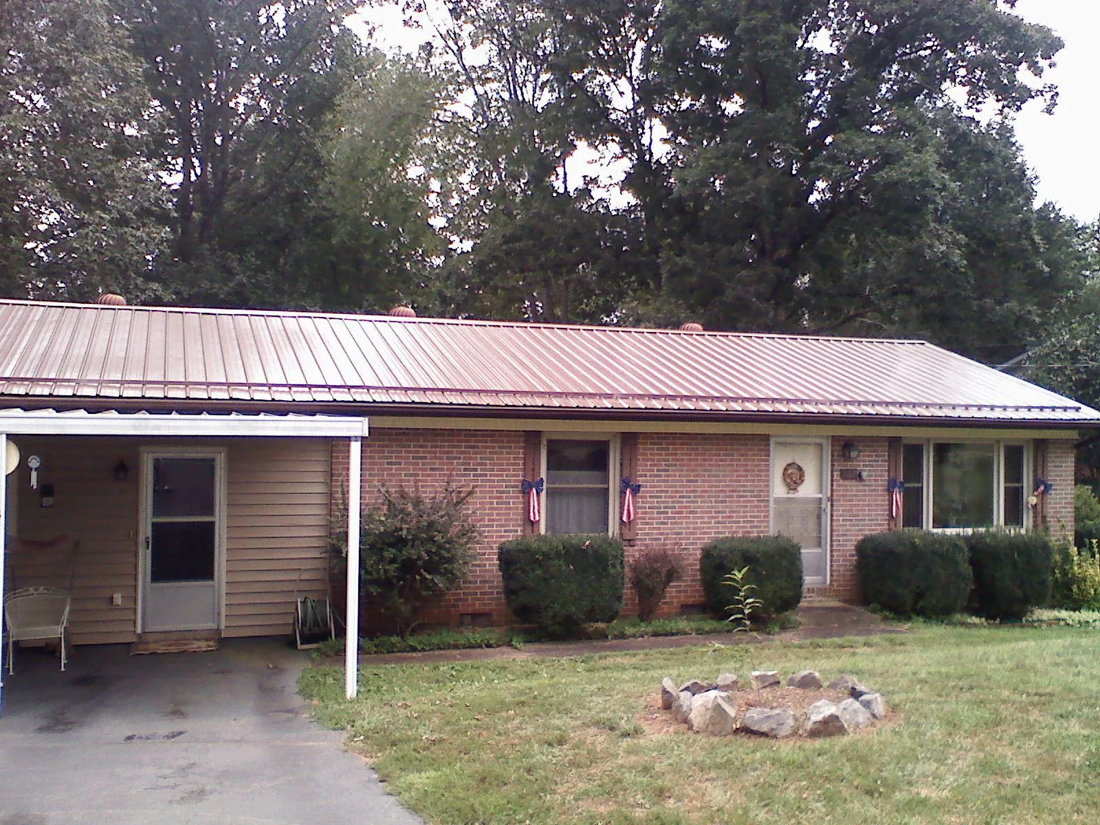 Bronze metal roof and carport on a brick ranch home — Roof Repair work by our crew in Essex